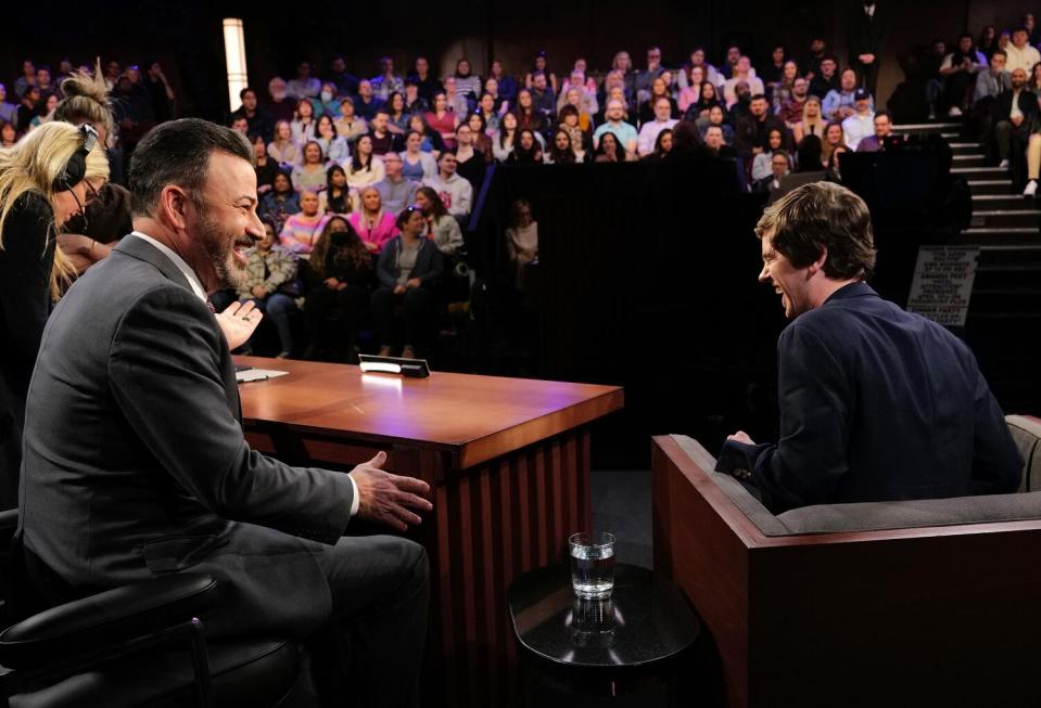 Jimmy Kimmel looks at Freddie Highmore in front of a studio audience.