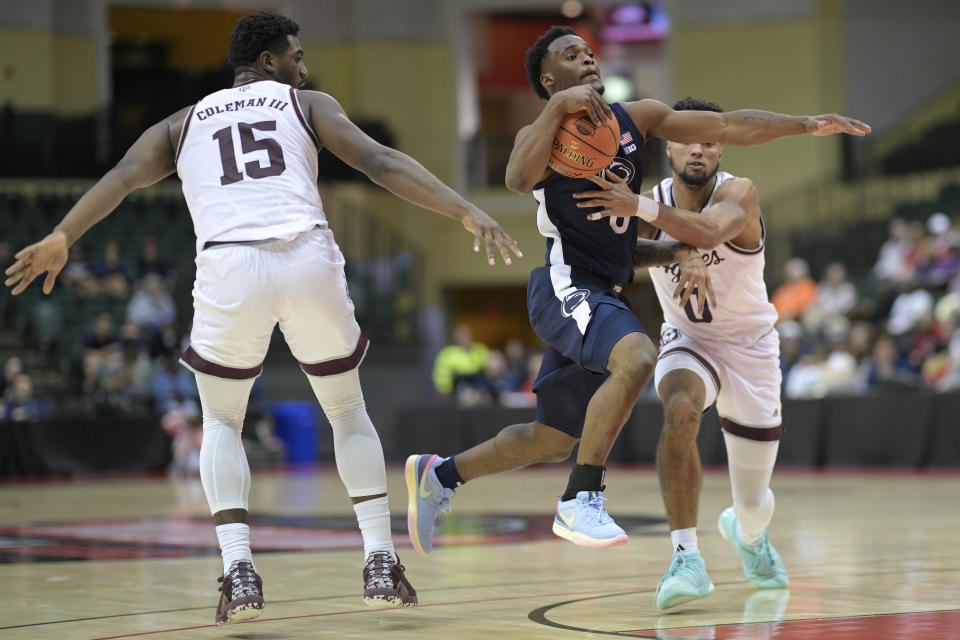 Penn State guard Kanye Clary, center, drives between Texas A&M forward Henry Coleman III (15) and guard Jace Carter (0) during the first half of an NCAA college basketball game, Thursday, Nov. 23, 2023, in Kissimmee, Fla. (AP Photo/Phelan M. Ebenhack)