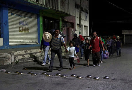 Central American migrants, part of a caravan moving through Mexico toward the U.S. border, walk to the bus station to take a bus bound for Puebla, in Matias Romero, Mexico April 5, 2018. REUTERS/Henry Romero