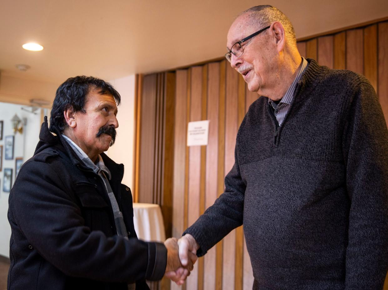 Roberto Tapia, who was receiving care at a mobile dental clinic, shakes hands with Ron Post, Medical Teams International's founder, for work done in the community and internationally on Jan. 30 in Salem.