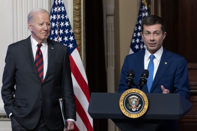 President Joe Biden (L) listens to Secretary of Transportation Pete Buttigieg (R) speak during an event to discuss efforts to reduce costs for customers by strengthening supply chains at the White House on Monday. Photo by Michael Reynolds/UPI