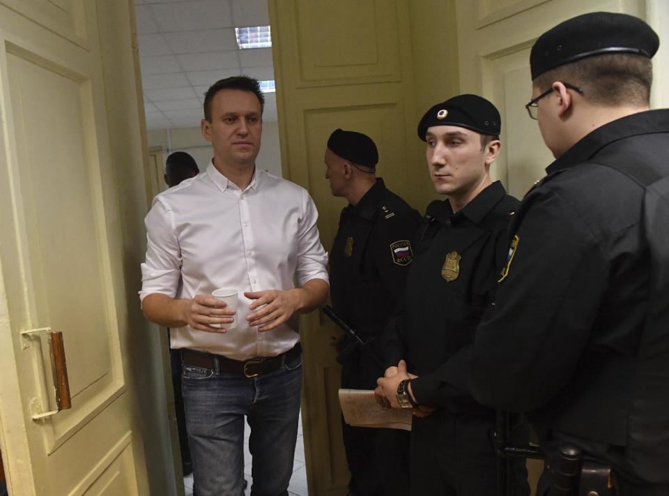 Russian opposition leader Alexei Navalny, left, enters the courtroom in Kirov, Russia, Wednesday, Feb. 8, 2017. A Russian court on Wednesday found opposition leader Alexei Navalny guilty in the retrial of a 2013 fraud case, which disqualifies him as a candidate for president next year. However, an associate said Navalny will carry on with the campaign he announced in December. (AP Photo/Sergei Bonurin)