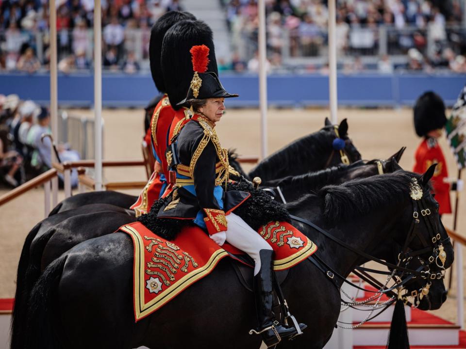 Princess Anne rides on horseback alongside King Charles during the Trooping the Colour military procession.