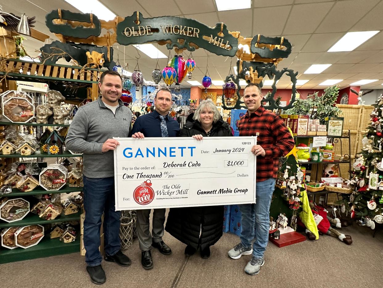 Gannett representative Chris Jadwick, second from left, presents Deborah Cuda, third from left, with the $1,000 prize, on Jan. 11 at the Olde Wicker Mill in New Hartford. Also pictured are Brandon Misiaszek, left, and David Misiaszek. The prize is part of the $25,000 nationwide Wish and Win Sweepstakes. Cuda is a Utica resident.