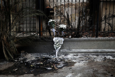 Flowers are laid on the spot where two people were found dead following a wildfire in the village of Mati, near Athens, Greece, July 26, 2018. REUTERS/Alkis Konstantinidis