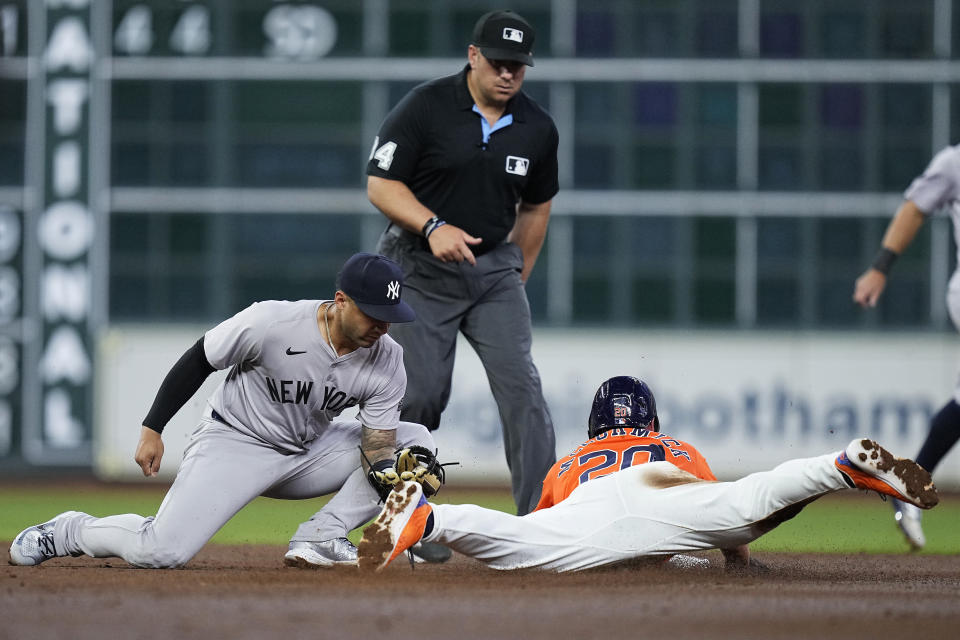 Houston Astros' Chas McCormick steals second as New York Yankees second baseman Gleyber Torres is late with the tag during the second inning of a baseball game Friday, March 29, 2024, in Houston. (AP Photo/Kevin M. Cox)