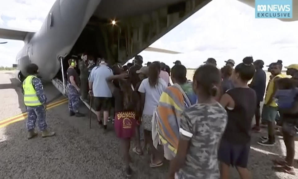 In this image made from video taken on March 21, 2019, storm evacuees board an Australian Defence Force C-130 plane preparing to take off from Borroloola, Australia. Two powerful cyclones are spinning toward Australia's sparsely populated north where around 2,000 people have been evacuated from the east coast of the Northern Territory ahead of strong winds, mountainous waves and flooding rain. (Australian Broadcasting Corporation via AP)