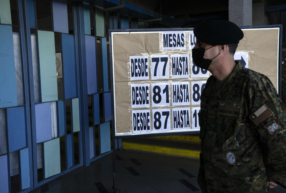 An Army officer walks inside a school that will serve as a polling station for Sunday's general elections, including presidential, in Santiago, Chile, Friday, Nov. 19, 2021. (AP Photo/Esteban Felix)