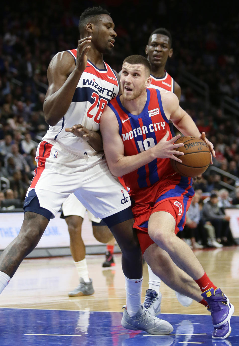 Detroit Pistons guard Sviatoslav Mykhailiuk (19) drives against Washington Wizards center Ian Mahinmi (28) during the first half of an NBA basketball game Thursday, Dec. 26, 2019, in Detroit. (AP Photo/Duane Burleson)