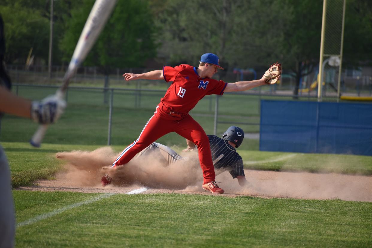 Martinsville's Ian Nuckles catches a pass and tries to tag out Decatur Central's Brayden Coffey, who was ruled safe. during the Artesians' game with Hawks on May 10, 2022.