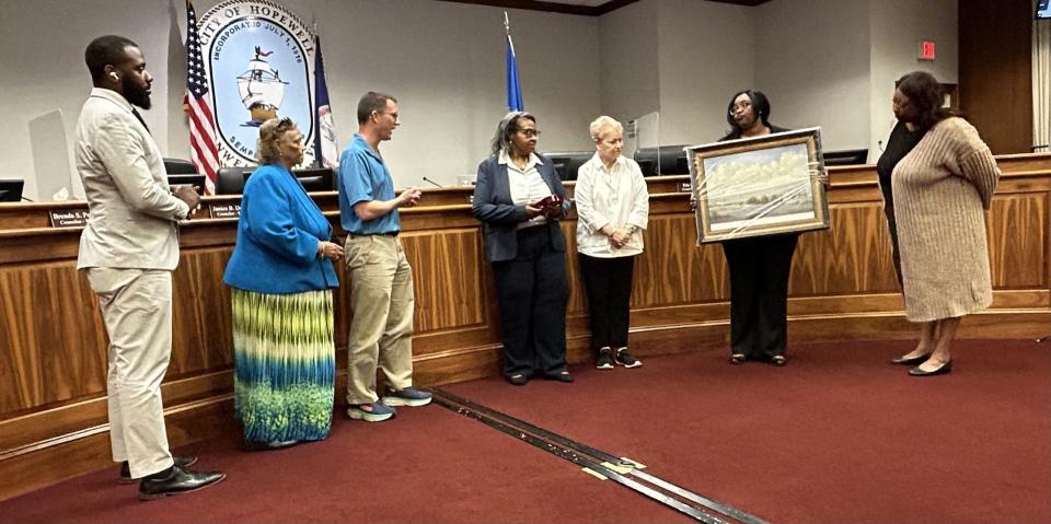 Hopewell City Council recognizes outgoing City Attorney Danielle Smith, center, at the conclusion of its meeting Tuesday, April 16, 2024. Smith's last day as the city's chief legal advisor is April 18. Presenting her with a plaque and a painting of the city of Hopewell are, from left, councilors Dominic Holloway and Brenda Pelham, Mayor Johnny Partin Jr.,, Councilor Rita Joyner, Vice Mayor Jasmine Gore and City Manager Dr. Concetta Manker.