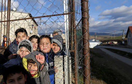 Roma children stand behind a fence near the so called "Sheffield Square" in the town of Bystrany, Slovakia, November 28, 2016. REUTERS/David W Cerny