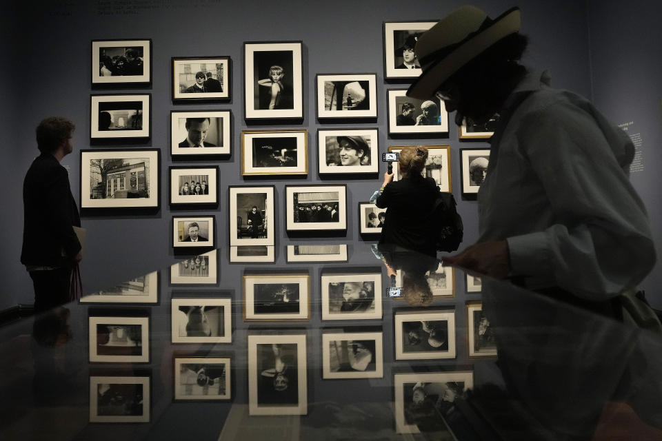 Visitors look at pictures during a preview of Paul McCartney Photographs 1963-64: Eyes of the Storm exhibition at the National Portrait Gallery in London, Britain, Tuesday, June 27, 2023. The exhibition consists of unseen photographs taken by Paul McCartney from the Beatles at the height of Beatlemania. The gallery will open it's doors from June 28, 2023 until October 1, 2023. (AP Photo/Frank Augstein)