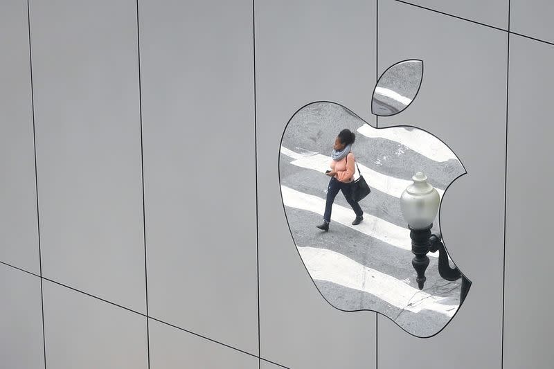 FILE PHOTO: A woman is reflected in a Apple store logo in San Francisco