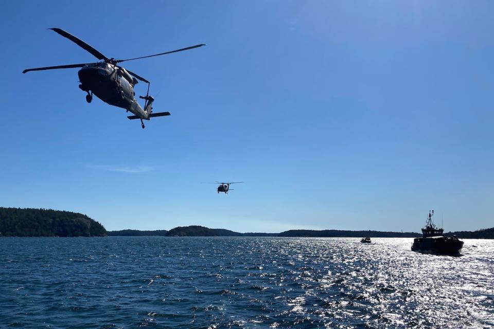 Swedish Black Hawk helicopters fly past the Navy ship that U.S. Defense Secretary Lloyd Austin travels on during a military demonstration through the islands in the southern Stockholm archipelago on Wednesday, April 19, 2023.