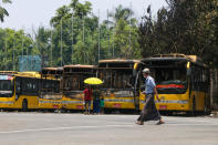 People look at a row of burnt public transport buses parked at Kyimyindaing township in Yangon, Myanmar Monday, April 12, 2021. Local news media reported that the buses got burned early Monday morning, but provided no details for the cause. (AP Photo)