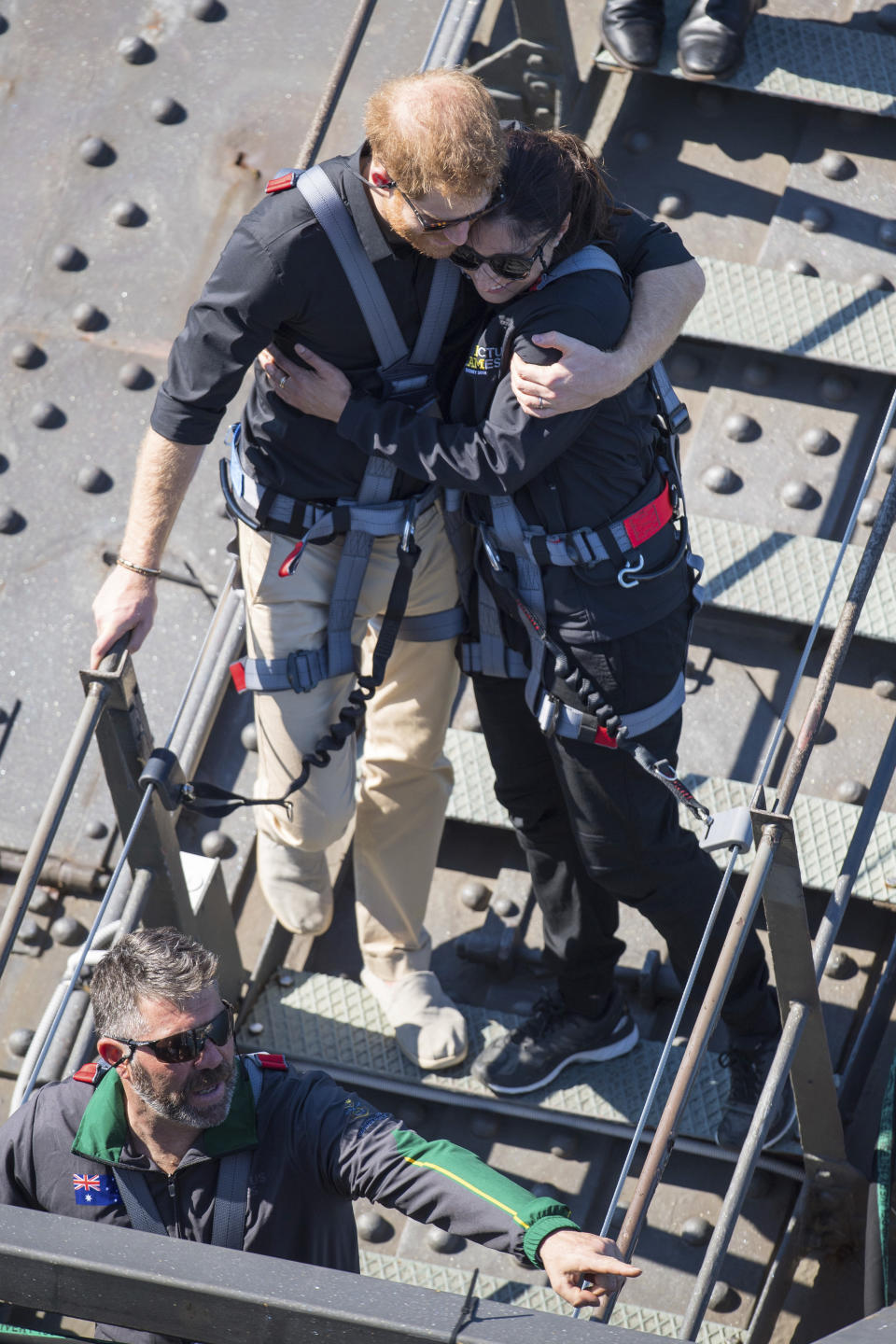 Britain’s Prince Harry, left, hugs a fellow climber during a visit to the Sydney Harbour Bridge with Prime Minister of Australia Scott Morrison and Invictus Games competitors in Sydney, Friday, Oct. 19, 2018. Prince Harry and his wife Meghan are on day four of their 16-day tour of Australia and the South Pacific.(Dominic Lipinski/Pool Photo via AP)