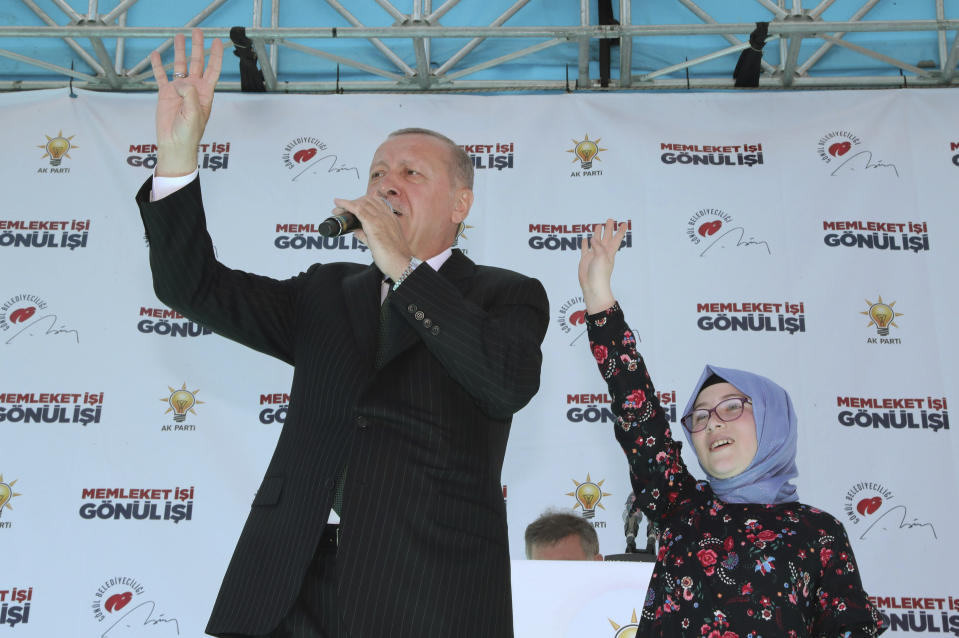 Turkey's President Recep Tayyip Erdogan waves to the supporters of his ruling Justice and Development Party with a young supporter, Sevval Cerrah, during a rally in Eregli, Turkey, Tuesday, March 19, 2019. Ignoring widespread criticism, Erdogan has again shown excerpts of a video taken by the attacker who killed 50 people in mosques in New Zealand at a campaign rally. (Presidential Press Service via AP, Pool)