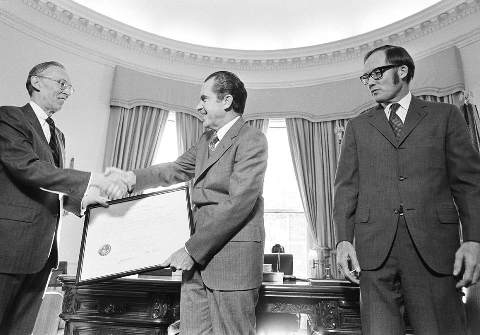 Nixon, center, shakes Lewis F. Powell, Jr.'s hand as William H. Rehnquist, right, looks on during a ceremony at the White House in Dec. 1971.