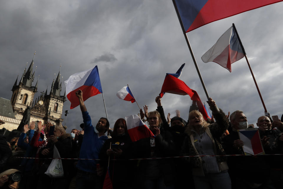 Demonstrators gather to protest against the COVID-19 restrictive measures at Old Town Square in Prague, Czech Republic, Sunday, Oct. 18, 2020. The Czech Republic has imposed a new series of restrictive measures in response to a record surge in coronavirus infections. Among the measures all sports indoor activities are banned and only up to 20 people are allowed to participate in outdoor sport activities also all bars, restaurants and clubs are closed while drinking of alcohol is banned at public places. (AP Photo/Petr David Josek)