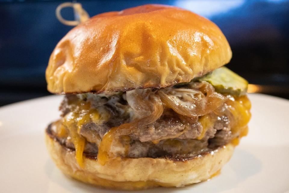 The Stoop Burger from Stoop Kid with double beef patties, cheddar cheese, pickles, caramelized onion and dijonaise on a brioche bun.