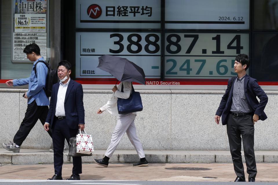 People stand in front of an electronic stock board showing Japan's Nikkei 225 index at a securities firm Wednesday, June 12, 2024, in Tokyo. (AP Photo/Eugene Hoshiko)