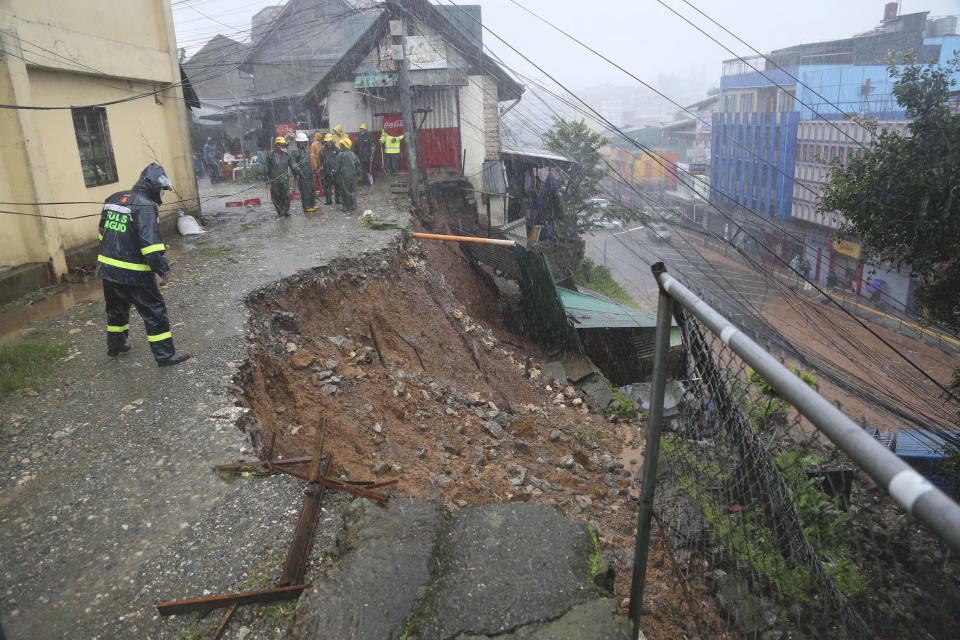 A police officer checks a landslide caused by Typhoon Doksuri at a residential area in Baguio City, northern Philippines on Wednesday, July 26, 2023. Typhoon Doksuri ripped off tin roofs from homes, engulfed low-lying villages in flood, knocked down power and displaced more than 12,000 people Wednesday as it smashed into a small island and lashed northern Philippine provinces overnight with ferocious wind and rain, officials said. (AP Photo)