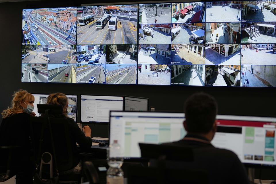 Police and traffic warden employees monitor screens showing the flow of people and web cameras at a police station, in Venice, Italy, Thursday, June 17, 2021. After a 15-month pause in mass international travel, Venetians are contemplating how to welcome visitors back to the picture-postcard canals and Byzantine backdrops without suffering the indignities of crowds clogging its narrow alleyways, day-trippers perched on stoops to imbibe a panino and hordes of selfie-takers straining for a spot on the Rialto Bridge or in front of St. Mark’s Basilica. (AP Photo/Luca Bruno)