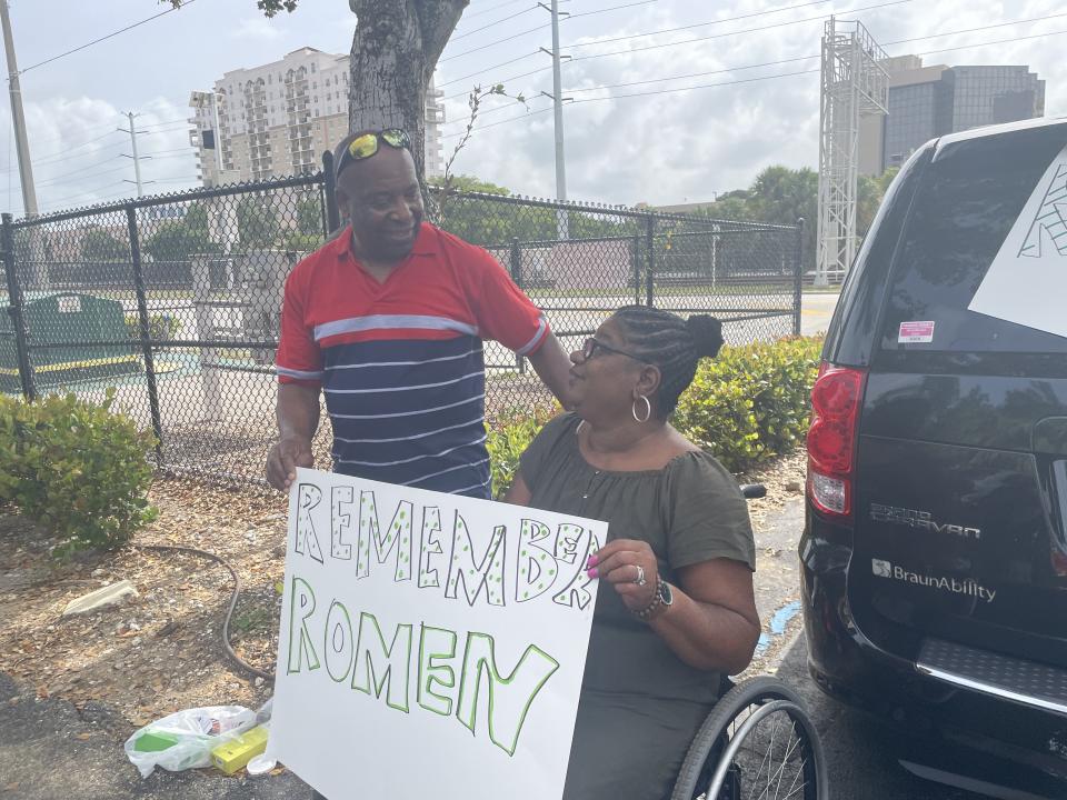 Robbin and Tony Jackman, the mother and stepfather of Romen Phelps, hold a handmade sign at a vigil Saturday for the 33-year-old, who was shot and killed by West Palm Beach police on campus at his alma mater, the Dreyfoos School of the Arts, on May 13.