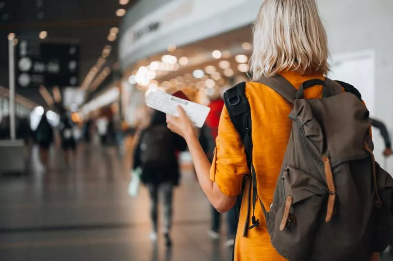 Woman at the airport holding a passport with a boarding pass