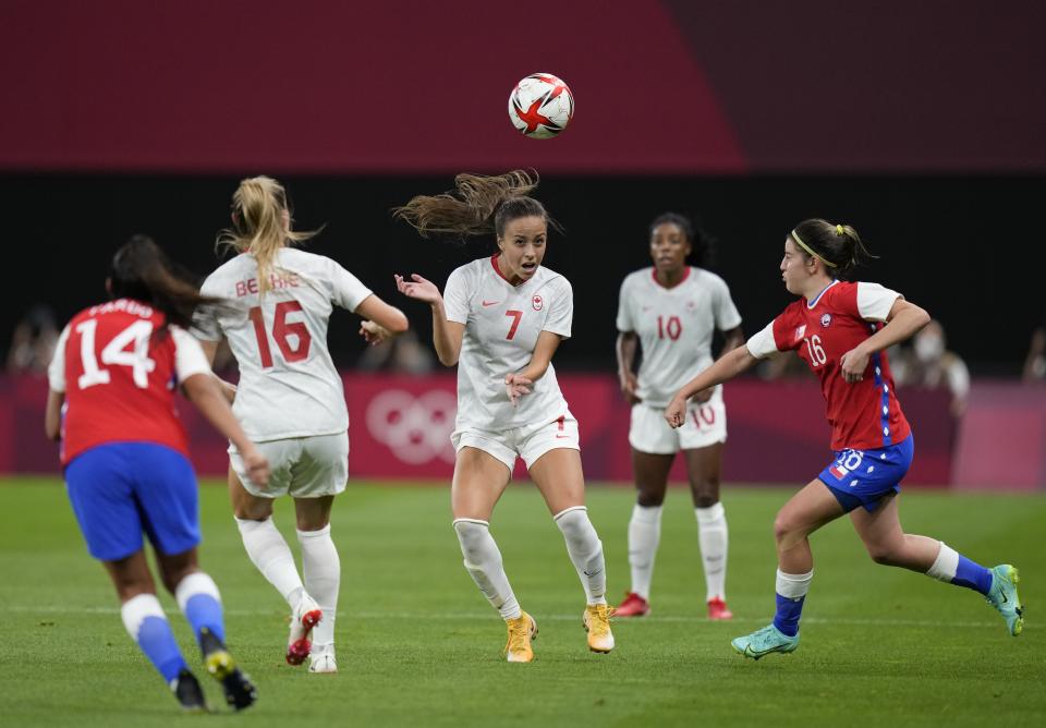 Canada's Julia Grosso, center, heads the ball during a women's soccer match against Chile at the 2020 Summer Olympics, Saturday, July 24, 2021, in Sapporo, Japan. (AP Photo/Silvia Izquierdo)