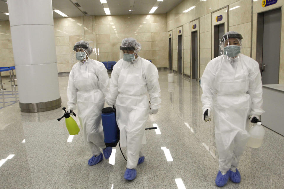 FILE - In this Feb. 1, 2020, file photo, State Commission of Quality Management staff armed with protective gear and disinfectant, prepare to check the health of travelers arriving from abroad at the Pyongyang Airport in Pyongyang, North Korea. As a new and frightening virus closes in around it, North Korea presents itself as a fortress, tightening its borders as cadres of health officials stage a monumental disinfection and monitoring program. (AP Photo/Jon Chol Jin, File)
