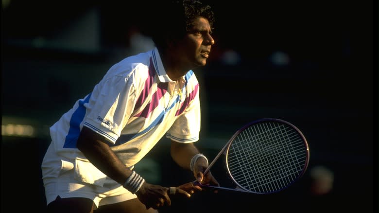 Tennis star Vijay Amritraj poised with his racket  