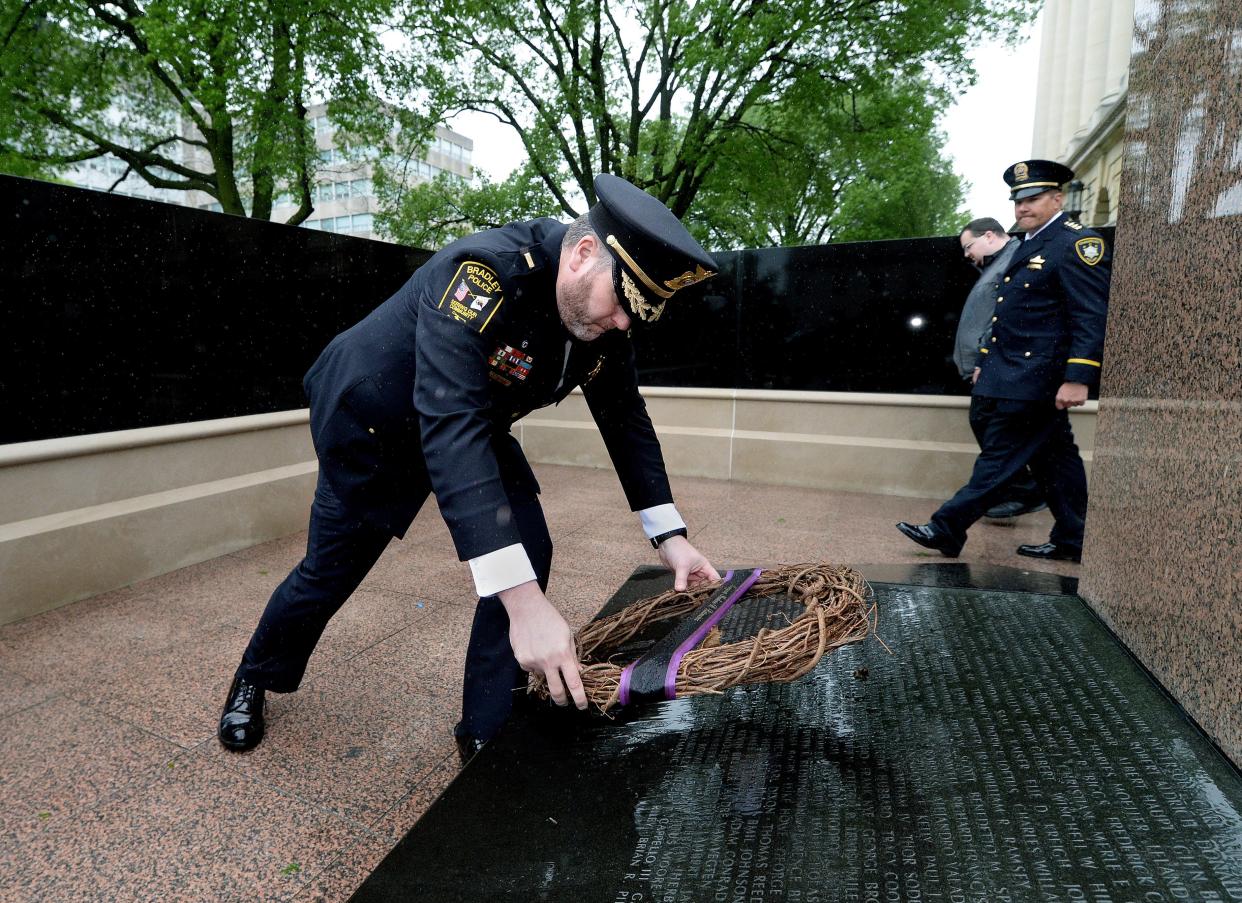 Philip Trudeau of the Bradley Police Department places a wreath for Sgt. Marlene Rittmanic at the Illinois Police Officers Memorial near the state Capitol after Thursday's ceremonies for fallen officers. Rittmanic, also of the Bradley Police Department, was killed Dec. 30, 2021. Rittmanic was Trudeau's friend and supervisor. [Thomas J. Turney/ The State Journal-Register]