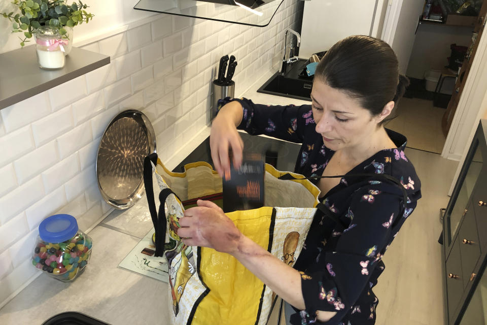 In this April 22, 2020, photo, Sabrina Deliry prepares a bag for her mother Patricia, 80, in her apartment in Paris, ahead of her first authorized visit in more than a month. Deliry hadn’t been allowed inside the Paris nursing home where her mother lives since early March, when such homes across France were locked down amid the coronavirus pandemic. They were allowed to meet for half an hour on Tuesday, in the home’s garden but were kept 1 meter apart. (AP Photo/John Leicester)
