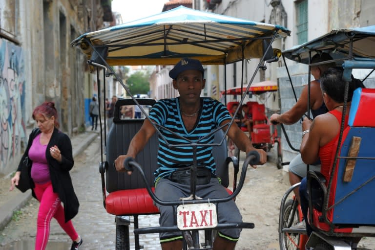 Jose Antonio Torres, a nurse who now works as a 'bicitaxi' or bicycle taxi driver, rides on a street in Havana