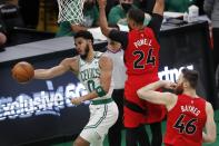 Boston Celtics' Jayson Tatum (0) passes off against Toronto Raptors' Norman Powell (24) and Aron Baynes (46) during the first half of an NBA basketball game, Thursday, Feb. 11, 2021, in Boston. (AP Photo/Michael Dwyer)