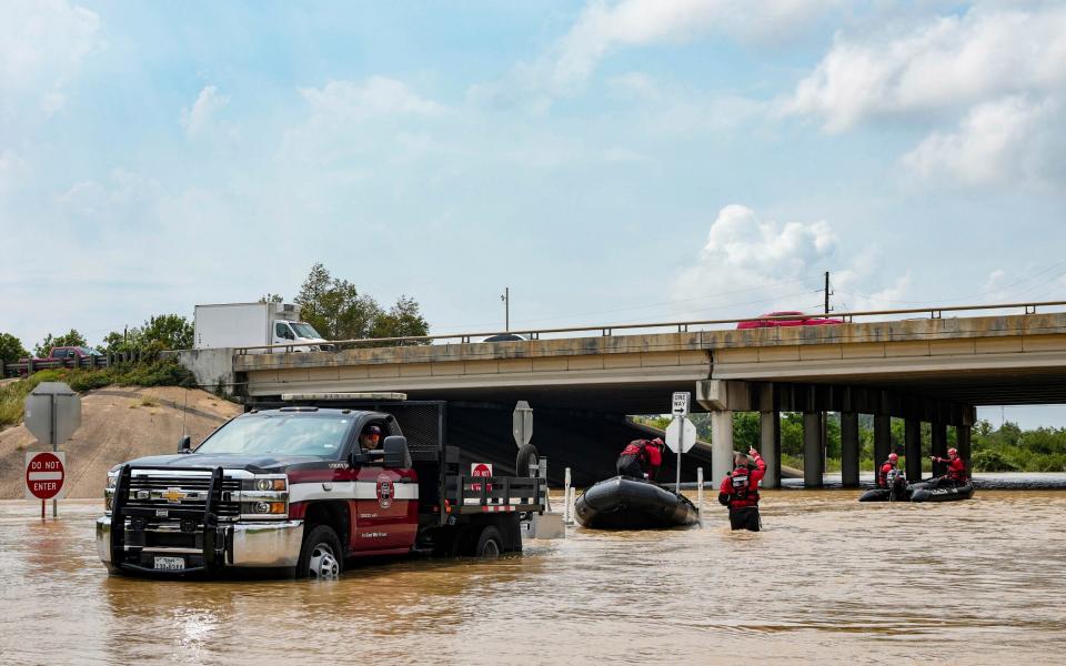Fire staff and police prepare to help evacuate an area due to severe flooding on Saturday at Channelview, east of Houston