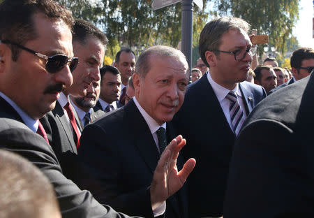 Turkish President Tayyip Erdogan greets people as he walks next to Serbia's President Aleksandar Vucic during their visit to Novi Pazar, Serbia, October 11, 2017. REUTERS/Marko Djurica