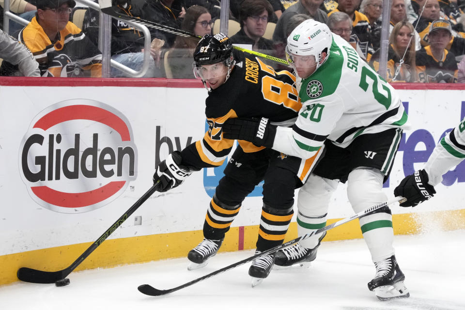 Pittsburgh Penguins' Sidney Crosby (87) works in the corner against Dallas Stars' Ryan Suter (20) during the second period of an NHL hockey game in Pittsburgh, Tuesday, Oct. 24, 2023. (AP Photo/Gene J. Puskar)