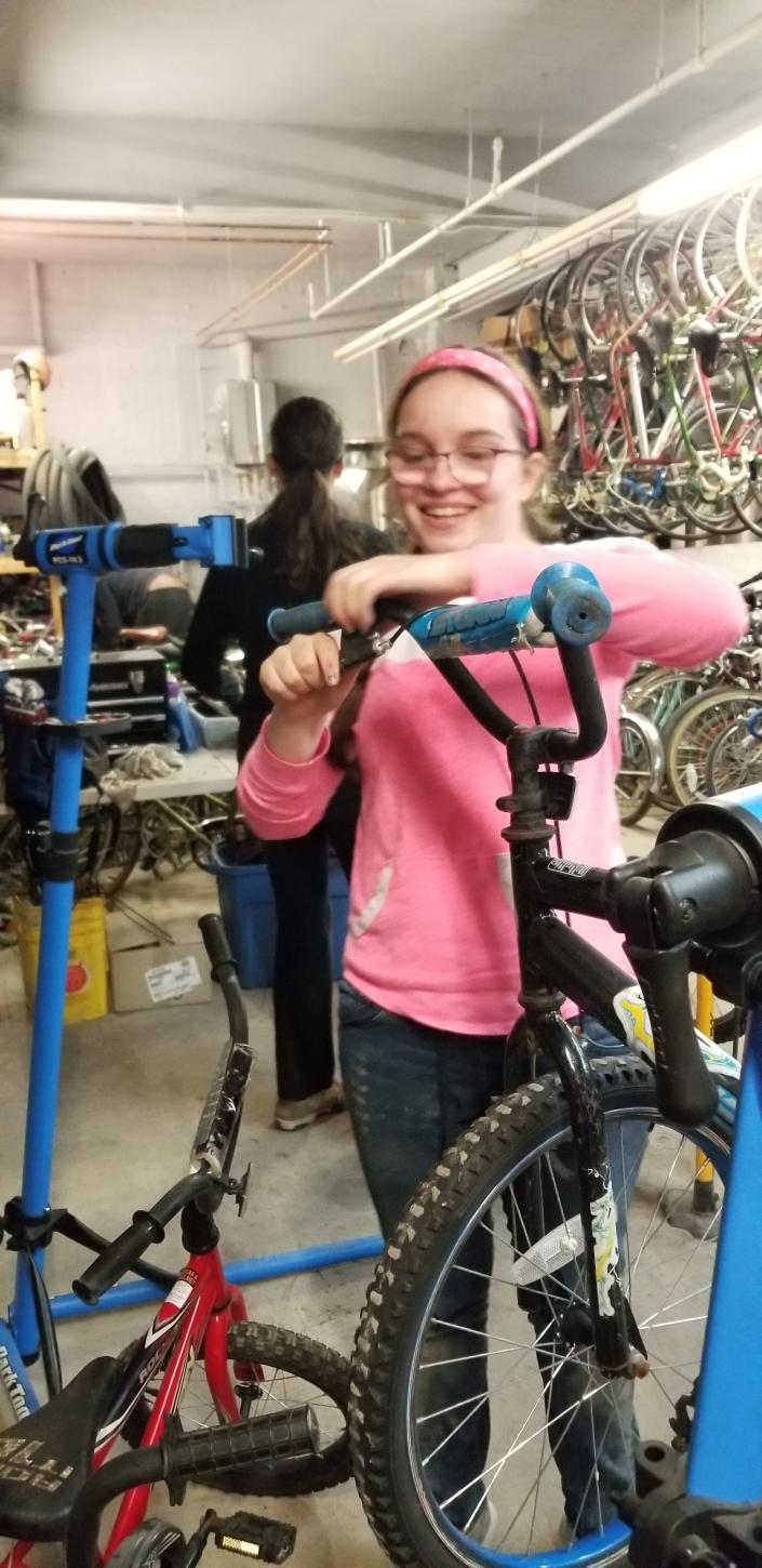 Kaijala is repairing a children's bike provided by the nonprofit organization Worcester Earn-A-Bike. The bike shop is at 4 King St. in Worcester.
