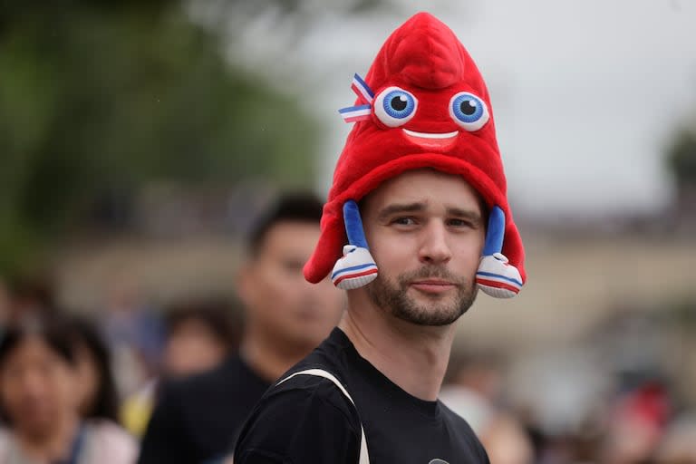 Un hombre lleva una gorra con la mascota de los Juegos Olímpicos París 2024