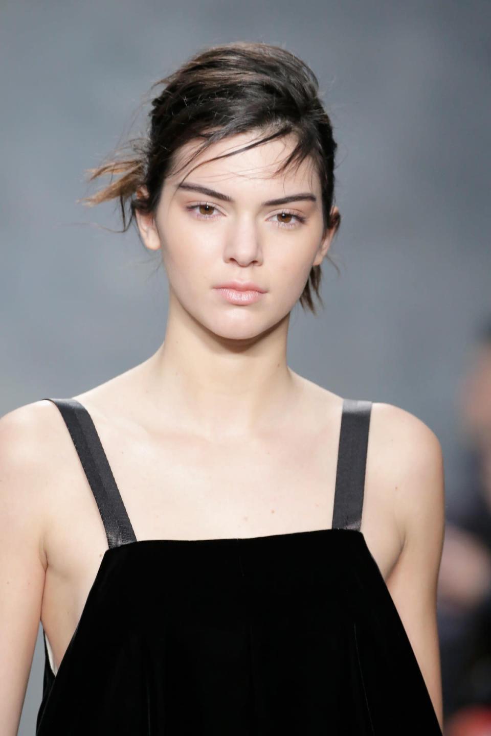 <p>What contouring? Walking the runway at Vera Wang Fall 2015, Jenner is barefaced with bold eyebrows and a messy updo. <i>(Photo: Getty Images)</i></p>