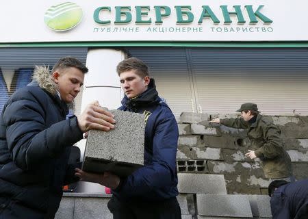 Members and supporters of the National corp political party erect a wall of concrete blocks outside a branch of Sberbank, which is the local subsidiary of Russia's largest lender, during a protest in Kiev, Ukraine, March 13, 2017. REUTERS/Valentyn Ogirenko