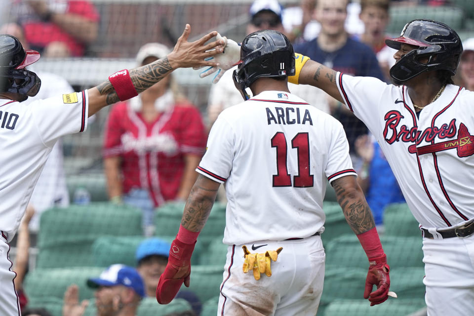 Atlanta Braves' Eddie Rosario, left, and Ronald Acuna Jr., right, celebrate after Orlando Arcia (11) scores in the fourth inning of a baseball game against the Los Angeles Angels, Wednesday, Aug. 2, 2023, in Atlanta. (AP Photo/Brynn Anderson)