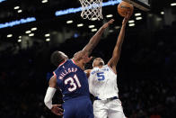 New York Knicks guard Immanuel Quickley (5) goes to the basket against Brooklyn Nets forward Paul Millsap (31) during the first half of an NBA basketball game, Tuesday, Nov. 30, 2021, in New York. (AP Photo/Mary Altaffer)