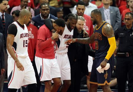 Atlanta Hawks forward DeMarre Carroll (5) is helped off the court after an apparent injury as Cleveland Cavaliers forward LeBron James (23) talks with him during the fourth quarter of game one of the Eastern Conference Finals of the NBA Playoffs against the Cleveland Cavaliers at Philips Arena. Cleveland won 97-89. Mandatory Credit: Brett Davis-USA TODAY Sports