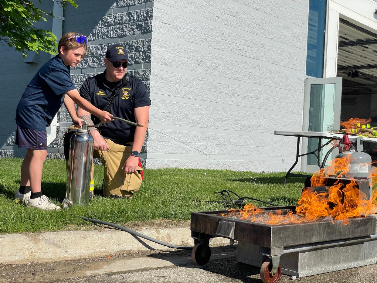 Gardens Elementary School fourth grader Jase Haddix, 10, putting out a fire at the Marysville Bike Rodeo on May 23, 2024.