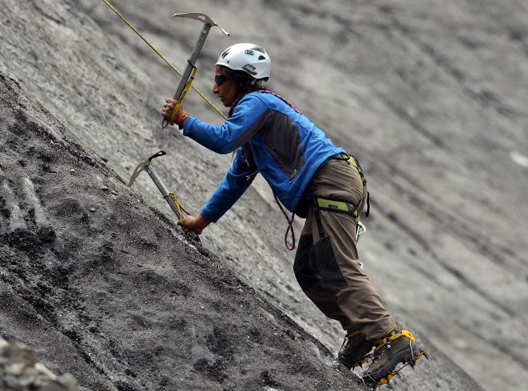 A student from the Shimshal Mountaineering School uses ice axes to climb a slope of a glacier in Pakistan's northern Hunza valley, on August 4, 2014