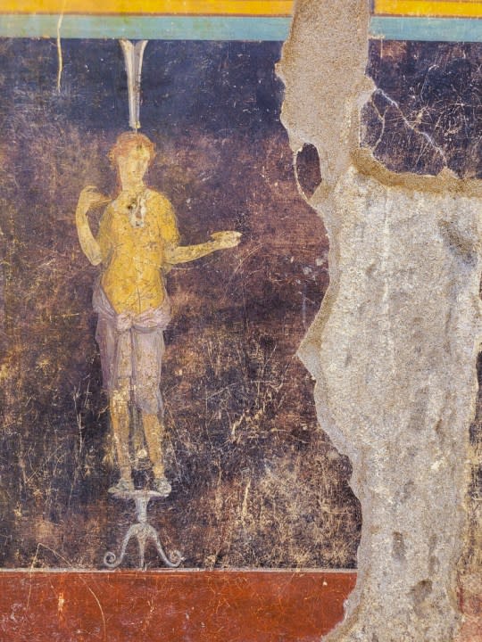 This image released by the Italian Culture Ministry on Wednesday, April 10, 2024, shows, part of the frescoes inside an imposing banquet hall, with elegant black walls, decorated with mythological subjects inspired by the Trojan War, which was recently unhearted in the Pompeii archaeological area near Naples in southern Italy. (Italian Culture Ministry via AP, HO)